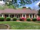 Charming brick home surrounded by lush greenery and mature trees, creating a serene and inviting curb appeal at 1614 Statesville Blvd, Salisbury, NC 28144