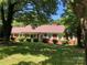 Charming brick home surrounded by lush greenery and mature trees, creating a serene and inviting curb appeal at 1614 Statesville Blvd, Salisbury, NC 28144