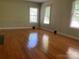 A bright living room featuring hardwood floors and ample natural light from three windows at 1614 Statesville Blvd, Salisbury, NC 28144
