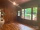 Cozy living room with wood paneling, hardwood floors, and bright windows at 1614 Statesville Blvd, Salisbury, NC 28144