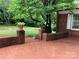 Back patio with a brick floor and brick wall with lush landscaping at 1614 Statesville Blvd, Salisbury, NC 28144
