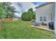Lush backyard featuring a patio, grill, seating, mature trees, and a wooden fence, offering a private outdoor space at 166 Glenn Allen Rd, Mooresville, NC 28115