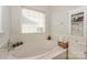 Bright bathroom featuring a soaking tub, a window with blinds, and built-in storage at 166 Glenn Allen Rd, Mooresville, NC 28115