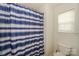 Well-lit bathroom featuring a striped shower curtain and a white toilet at 166 Glenn Allen Rd, Mooresville, NC 28115