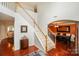 Bright foyer with hardwood floors, white staircase, and views into the dining room at 166 Glenn Allen Rd, Mooresville, NC 28115