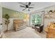 Cozy Bedroom featuring a wood crib, accent wall, ceiling fan, and a window with natural light at 1730 Eden Glen Dr, Dallas, NC 28034