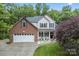 Charming two-story home featuring a well-manicured lawn, brick accents, and an attached two-car garage at 1730 Eden Glen Dr, Dallas, NC 28034