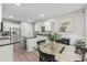 Bright, all-white kitchen featuring an island with seating, stainless steel appliances, and an open dining area at 1730 Eden Glen Dr, Dallas, NC 28034