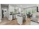 Well-lit kitchen with white cabinets, stainless steel appliances, a kitchen island, and an adjacent dining area at 1730 Eden Glen Dr, Dallas, NC 28034
