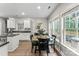 Bright kitchen and breakfast nook featuring hardwood floors, white cabinets, and natural light from large windows at 1730 Eden Glen Dr, Dallas, NC 28034