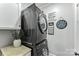 Modern laundry room with stacked washer and dryer, complemented by stylish decor and plant accents at 1730 Eden Glen Dr, Dallas, NC 28034