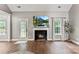 Bright living room with a fireplace, large TV, hardwood floors, and natural light streaming through the windows at 1730 Eden Glen Dr, Dallas, NC 28034