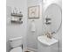 Stylish powder room featuring a modern vanity, round mirror, decorative shelves, and updated fixtures at 1730 Eden Glen Dr, Dallas, NC 28034