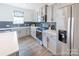 Bright kitchen featuring stainless steel appliances, sleek gray cabinets, and a modern black backsplash at 205 Cliffwood Nw St # A-1, Concord, NC 28027