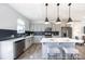Well-lit kitchen featuring stainless steel appliances, a breakfast bar, and elegant dark backsplash at 205 Cliffwood Nw St # A-1, Concord, NC 28027