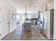 Spacious kitchen offering stainless steel appliances, a kitchen island, and a dining area with modern decor at 205 Cliffwood Nw St # A-1, Concord, NC 28027