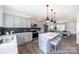Open-concept kitchen featuring a center island with seating, stainless steel appliances, and modern lighting at 205 Cliffwood Nw St # A-1, Concord, NC 28027