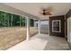 Covered back porch featuring a ceiling fan, white columns and a view of the yard and wooded area at 209 Stafford Estates Dr, Salisbury, NC 28146