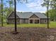A tranquil backyard view showcasing a covered patio, set against a backdrop of lush greenery and serene skies at 209 Stafford Estates Dr, Salisbury, NC 28146
