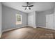 Light filled bedroom showing neutral walls, wood flooring, ceiling fan, window, and closet at 209 Stafford Estates Dr, Salisbury, NC 28146