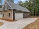 View of the garage with concrete driveway, stone and siding exterior at 209 Stafford Estates Dr, Salisbury, NC 28146