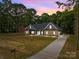 Charming single-story home featuring a stone and gray facade with a welcoming front yard and long driveway at 209 Stafford Estates Dr, Salisbury, NC 28146