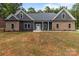 An inviting single-story home featuring a stone and gray facade with an unfinished front lawn at 209 Stafford Estates Dr, Salisbury, NC 28146