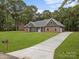 Charming single-story home featuring a well-manicured lawn and inviting stone and siding exterior at 209 Stafford Estates Dr, Salisbury, NC 28146