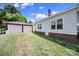 Wide backyard with grass, a detached two-car garage, and brick foundation at 220 Parker Ave, Mooresville, NC 28115