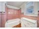 Retro bathroom with pink tiling, a tub with shower, and a white vanity at 220 Parker Ave, Mooresville, NC 28115