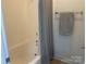 Clean bathroom features a shower with neutral curtain, and tile walls, a simple towel rack, and tiled floor at 2411 Bonterra Blvd, Indian Trail, NC 28079