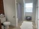 Well-lit bathroom featuring a toilet, shower with curtain, and a sleek basket for added storage and style at 2411 Bonterra Blvd, Indian Trail, NC 28079
