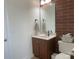 Cozy bathroom with vanity, mirror, and brick accent wall adding character at 2411 Bonterra Blvd, Indian Trail, NC 28079