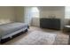 Comfortable bedroom with a full bed, dark dresser, and neutral rug creating a relaxing and inviting atmosphere at 2411 Bonterra Blvd, Indian Trail, NC 28079