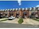 View of townhomes with brick facades, wood balconies, and ample parking on a sunny day at 2411 Bonterra Blvd, Indian Trail, NC 28079