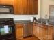 Modern kitchen with black appliances, granite counters, and wooden cabinets at 2411 Bonterra Blvd, Indian Trail, NC 28079