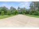 Long concrete driveway with stone entrance pillars and black fencing at 2949 Anderson Burgess Rd, Sharon, SC 29742