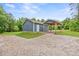 View of the blue garage and open sided shed in the backyard with a gravel driveway at 2949 Anderson Burgess Rd, Sharon, SC 29742