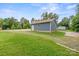 View of a blue vinyl garage with concrete and gravel driveway, green grass, and a solar panel array at 2949 Anderson Burgess Rd, Sharon, SC 29742