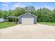 A blue garage showing the garage door and a concrete driveway with grass and a solar panel array at 2949 Anderson Burgess Rd, Sharon, SC 29742
