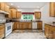 A spacious kitchen with wood cabinetry, white appliances, tile floors, and a sink with a view at 2949 Anderson Burgess Rd, Sharon, SC 29742