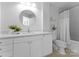 Clean bathroom with a white vanity, granite countertop, a round mirror and a shower-tub combo at 300 W Fifth St # 509, Charlotte, NC 28202