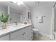 Bright bathroom features double vanity with stone countertop, round mirror and a shower-tub combo at 300 W Fifth St # 509, Charlotte, NC 28202