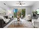 Bright living room with ceiling fan, access to a private balcony, and comfortable seating at 300 W Fifth St # 509, Charlotte, NC 28202