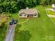 Aerial view of house with large front yard, driveway with cars, and surrounding landscape at 3125 Leonard Dr, Gastonia, NC 28056