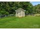 View of the storage shed in the fenced in backyard with green grass at 3125 Leonard Dr, Gastonia, NC 28056