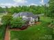Backyard view of home with a screened porch, outdoor kitchen, and manicured lawn at 3500 Maple Wood Dr, Denver, NC 28037