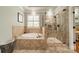 Elegant bathroom with a soaking tub, glass-enclosed shower, and neutral tile at 3500 Maple Wood Dr, Denver, NC 28037