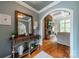 Entryway showcasing console table, mirror, hardwood floors, and archway to a living room at 3500 Maple Wood Dr, Denver, NC 28037