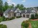 Well-maintained exterior featuring a stone and siding combination, two-car garage and mature landscaping at 3500 Maple Wood Dr, Denver, NC 28037